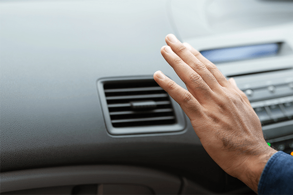 An image of a hand felling a cars air conditioning